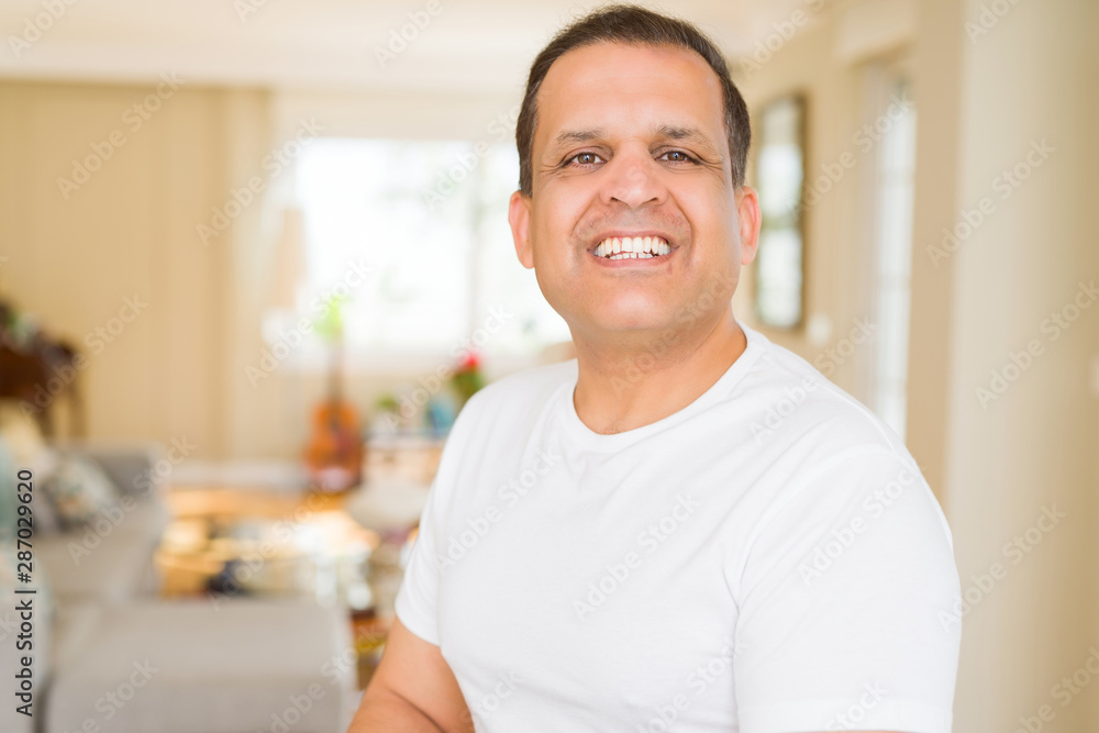 Middle age man smiling confident to the camera at home