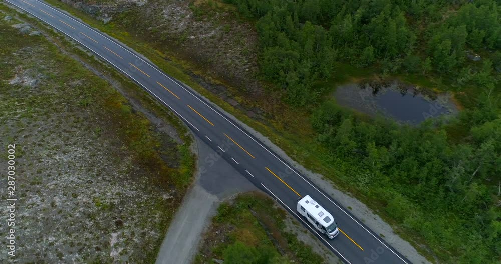 Aerial: Drone shot of camper van moving on road amidst land - Oppland, Norway Aerial: Drone shot of camper van moving on road amidst land - Oppland, Norway