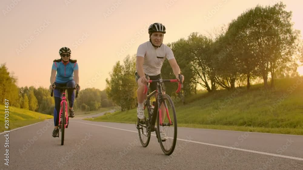 Cyclist Riding On Road Bike Rear View.Cycling Men Pedalling Road Bicycle On City Park.Tracking Shot Of Cyclist Rides On Road Bike At Sunset Sun.Cyclist Athlete Intensive Training On Bicycle. Cyclist Riding On Road Bike Rear View.Cycling Men Pedalling Road Bicycle On City Park.Tracking Shot Of Cyclist Rides On Road Bike At Sunset Sun.Cyclist Athlete Intensive Training On Bicycle.