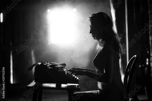A girl prints on an old typewriter