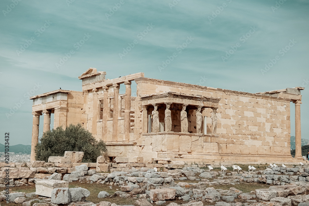 View of the Erechtheion temple at the Athens Acropolis in Athens Greece on a warm summer day with Lykavittos Hill in the background View of the Erechtheion temple at the Athens Acropolis in Athens Greece on a warm summer day with Lykavittos Hill in the background