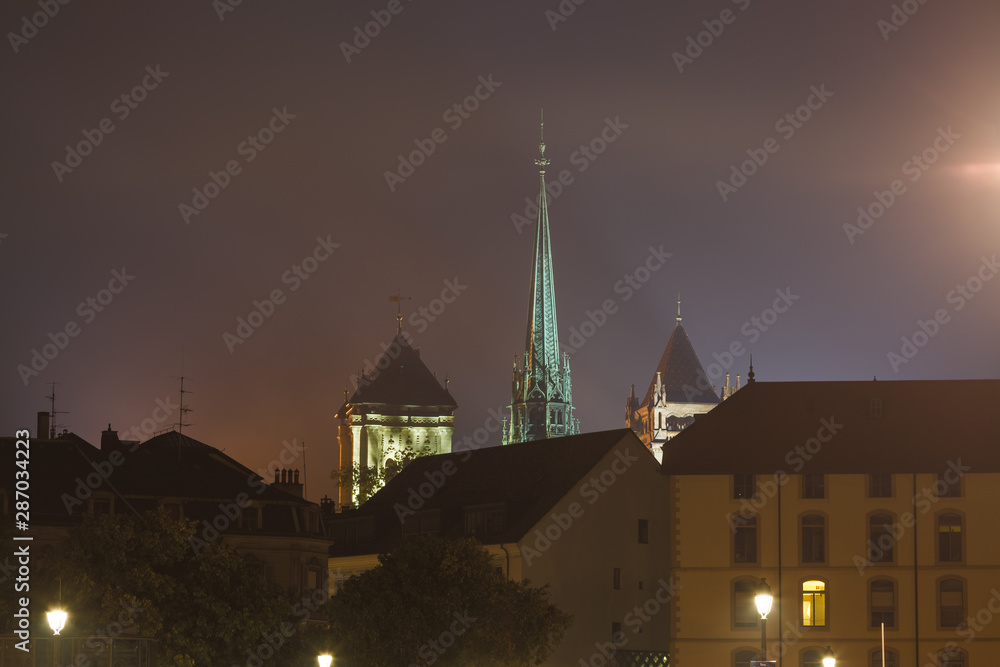 Fototapeta premium St. Pierre Cathedral (St. Peter's Cathedral) spire highlighted above Geneva city at night, Geneva, Switzerland