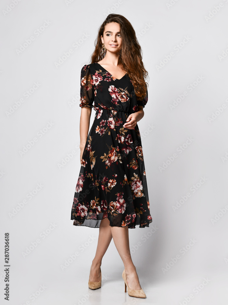 Slim curly female model in a silk dress looking at the camera in full growth. Cute girl in romantic clothes is going on a date Slim curly female model in a silk dress looking at the camera in full growth. Cute girl in romantic clothes is going on a date