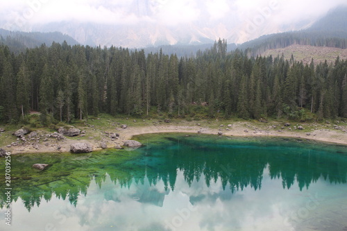 Lake Carezza  mountain lake famous for the dark green color and the beautiful panorama of mountains in the background. Reflection of the Rose Garden in the Lake. South Tirol  Italy