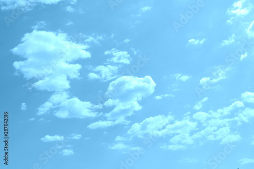 White clouds in a blue sky in a cloudy summer day © svlase