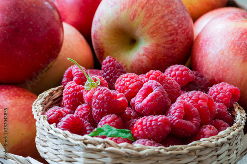 fresh raspberries and apples in a basket