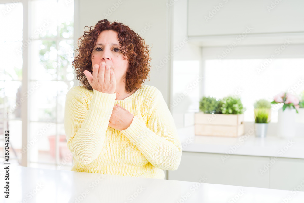 Beautiful senior woman wearing yellow sweater looking at the camera blowing a kiss with hand on air being lovely and sexy. Love expression. Beautiful senior woman wearing yellow sweater looking at the camera blowing a kiss with hand on air being lovely and sexy. Love expression.