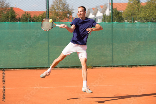 young man playing tennis © Tom Kuest