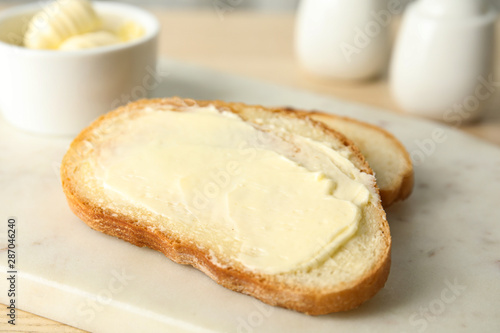 Tasty bread with butter for breakfast on marble board
