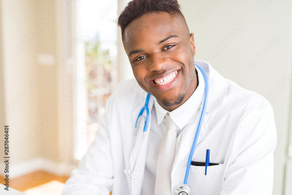 Young african american doctor smiling to the camera wearing stethoscope at the clinic Young african american doctor smiling to the camera wearing stethoscope at the clinic