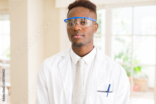 African young scientist man wearing safety glasses working with chemical equipment