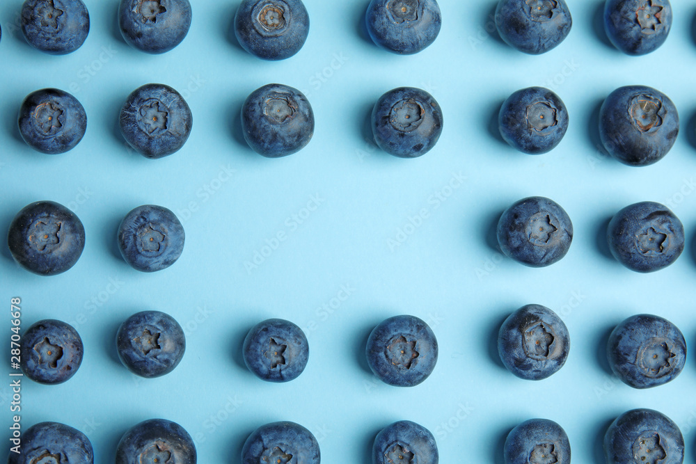 Frame of ripe blueberries on blue background, flat lay with space for text Frame of ripe blueberries on blue background, flat lay with space for text