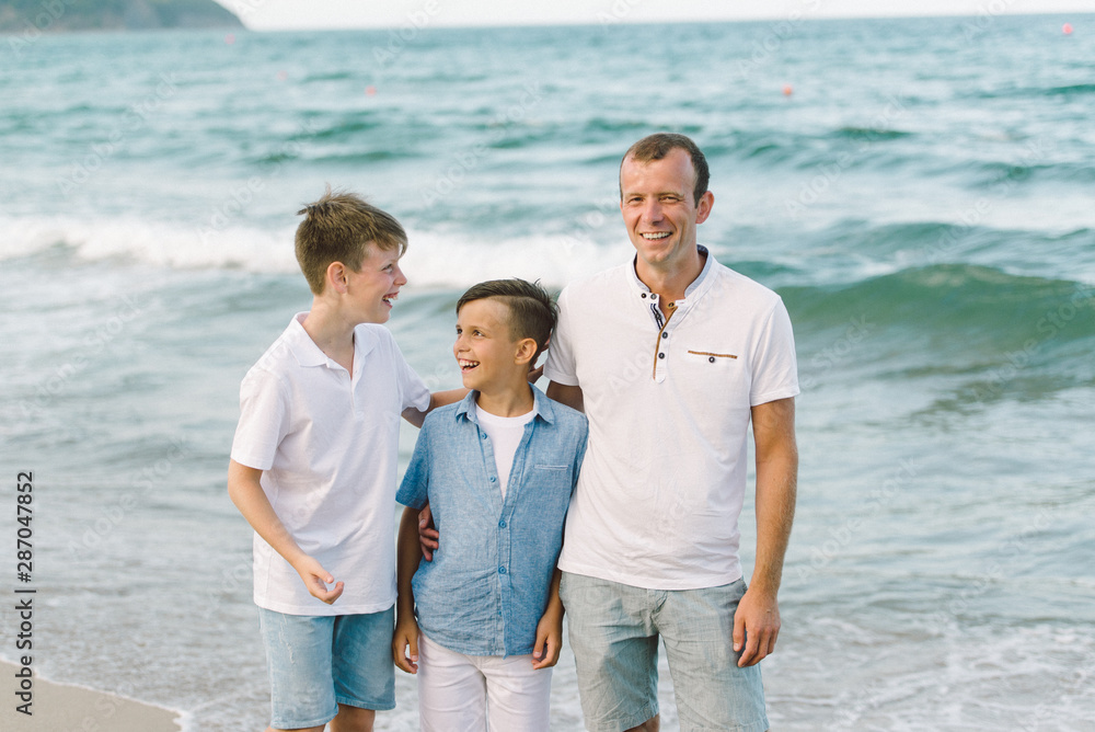 The father with sons on the sea beach The father with sons on the sea beach