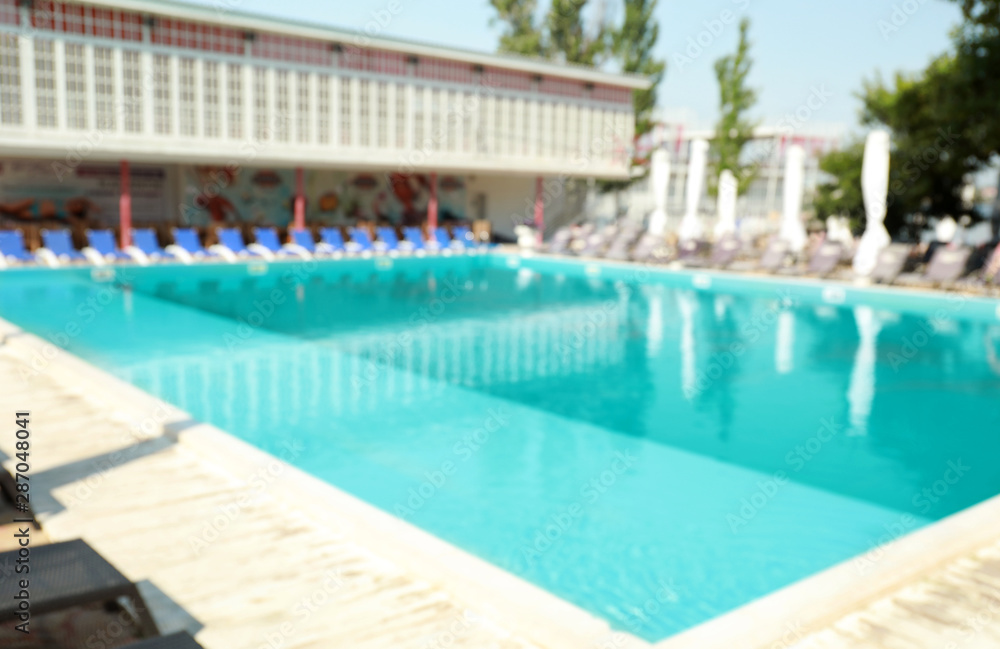 Blurred view of clean swimming pool on sunny day Blurred view of clean swimming pool on sunny day