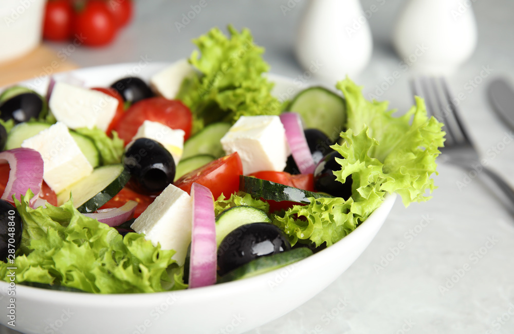 Tasty fresh Greek salad on grey table, closeup Tasty fresh Greek salad on grey table, closeup
