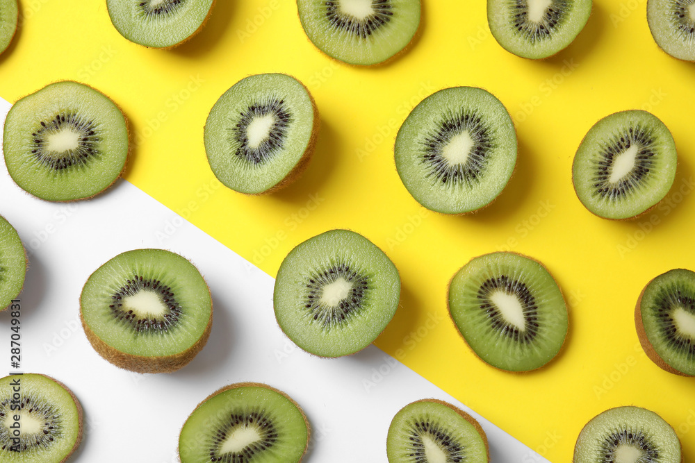 Fototapeta premium Top view of sliced fresh kiwis on color background