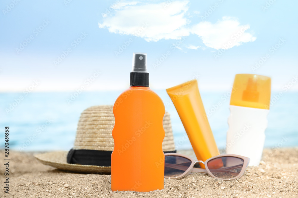 Composition with bottles of sun protection body cream on beach, space for design Composition with bottles of sun protection body cream on beach, space for design