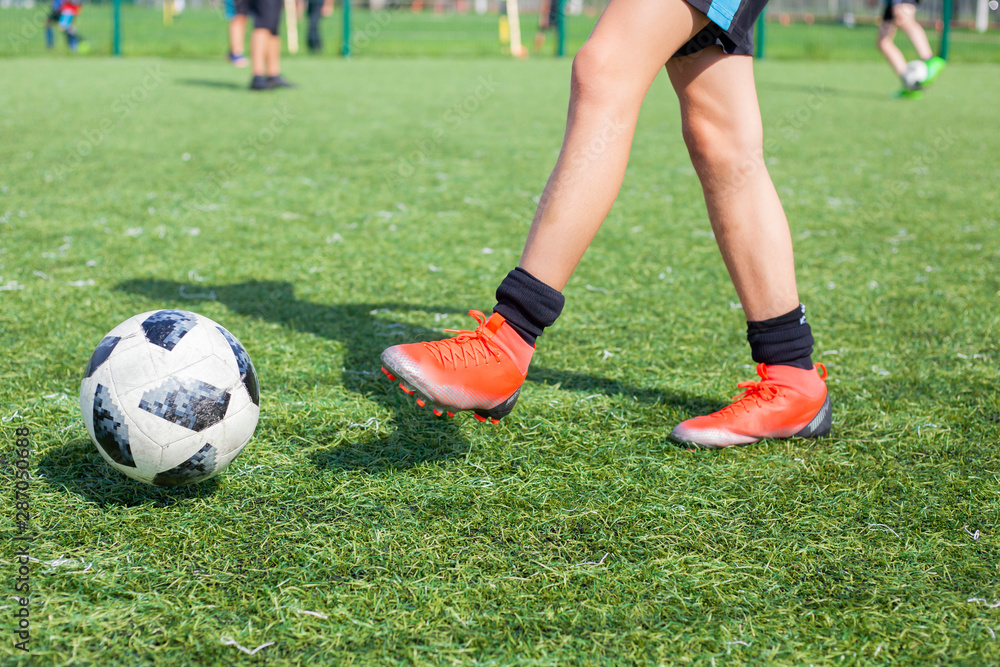 Soccer player on the soccer field plays the ball. Doing sports. Children play ball in a football team.