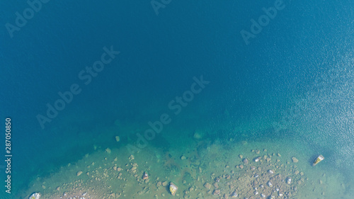 Aerial view of the deep blue lake and the rock