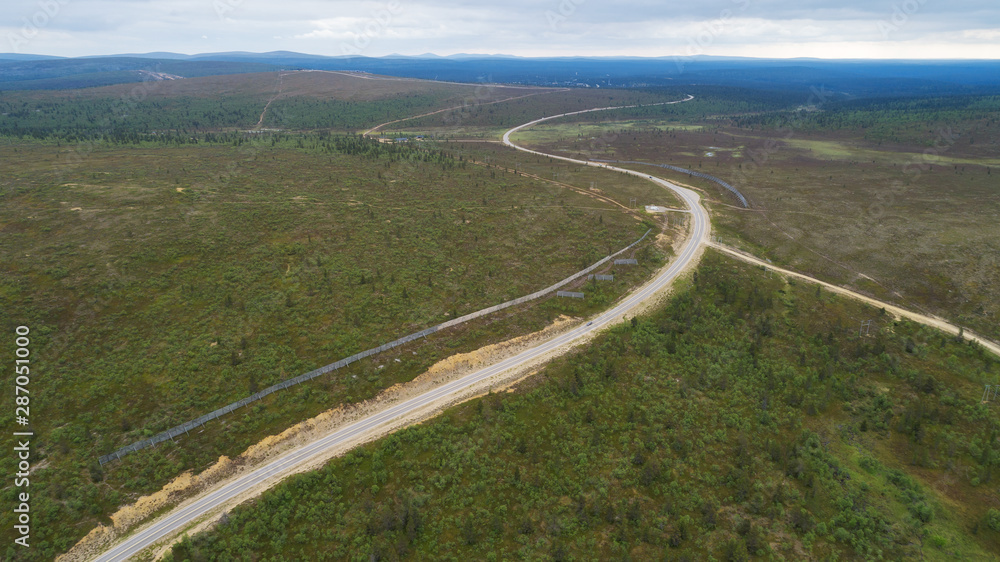 Winding road from mountain pass, in summer time. Aerial view by drone. 