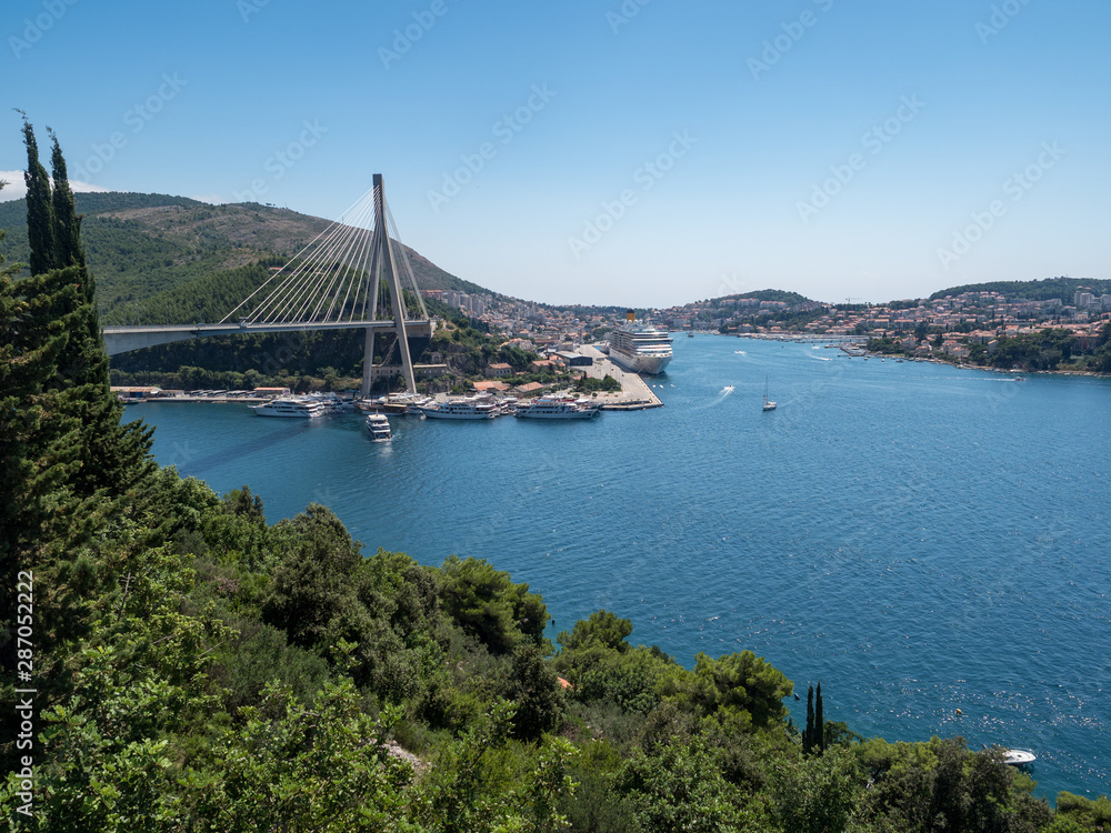 Croatia, august 2019: The Franjo Tudjman bridge and blue lagoon with harbor of Dubrovnik, Dalmatia. Croatia, august 2019: The Franjo Tudjman bridge and blue lagoon with harbor of Dubrovnik, Dalmatia.