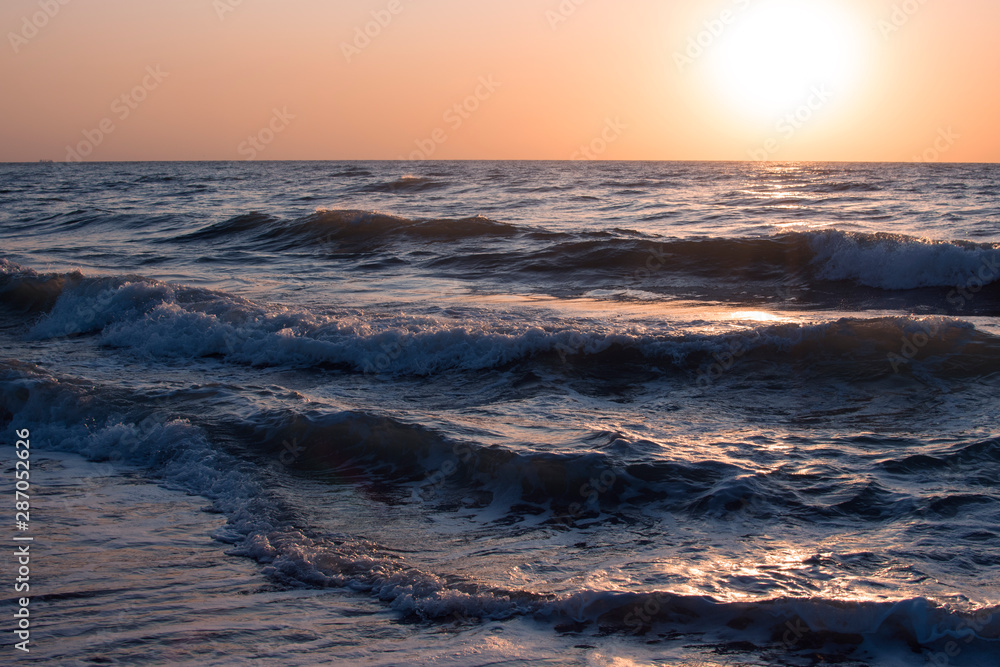 Obraz premium Sunset or dawn on the sea, waves and the sun.