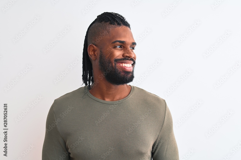 African american man with braids wearing green sweater over isolated white background looking away to side with smile on face, natural expression. Laughing confident. African american man with braids wearing green sweater over isolated white background looking away to side with smile on face, natural expression. Laughing confident.
