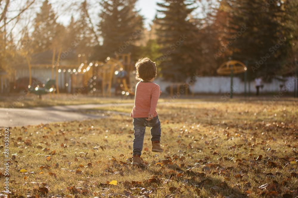Little boy running to a playground in a park Little boy running to a playground in a park