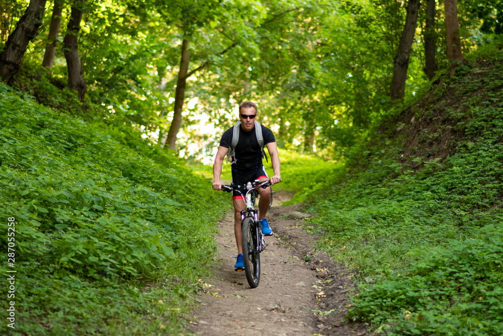 Fototapeta premium A man on a bicycle descends from the mountain.