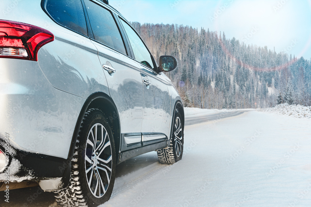 Modern Suv car stay on roadside of winter road. Family trip to ski resort concept. Winter or spring holidays adventure. car on winter snowy road in mountains