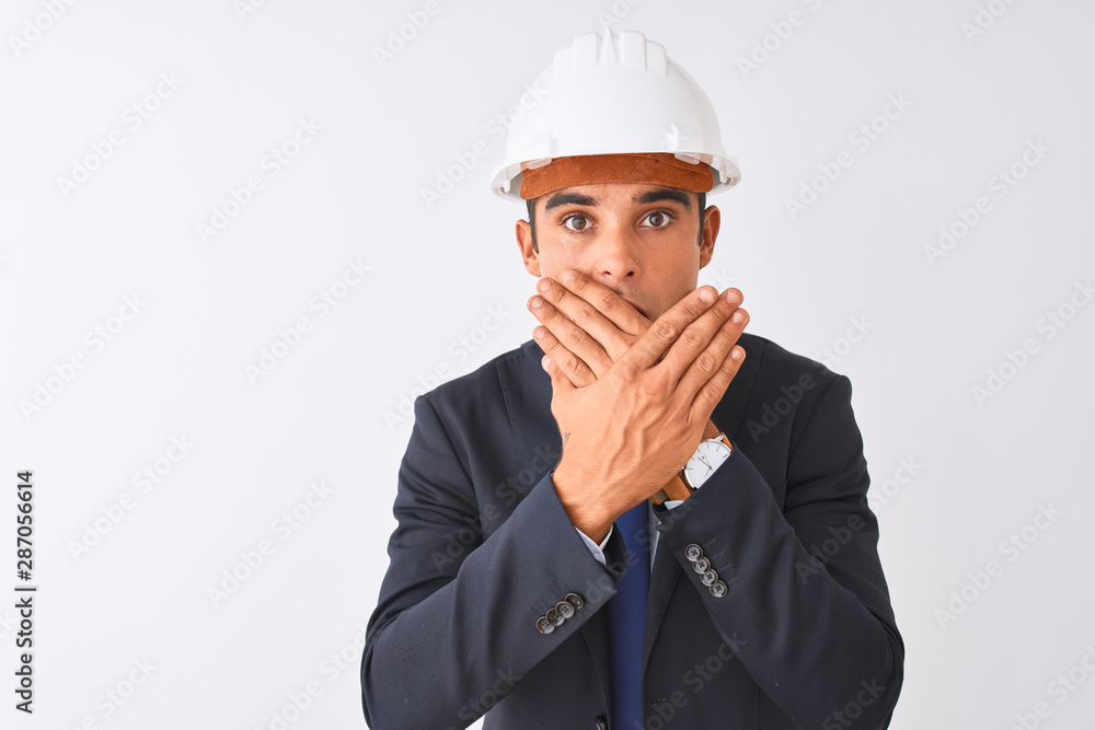 Young handsome architect man wearing suit and helmet over isolated white background shocked covering mouth with hands for mistake. Secret concept. Young handsome architect man wearing suit and helmet over isolated white background shocked covering mouth with hands for mistake. Secret concept.