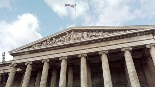 Walking In Front Of The British Museum In London, Uk, with waving flag on top photo