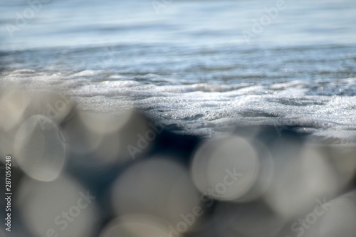 Large bokeh of the sea shore and foam on the surface of the water. photo