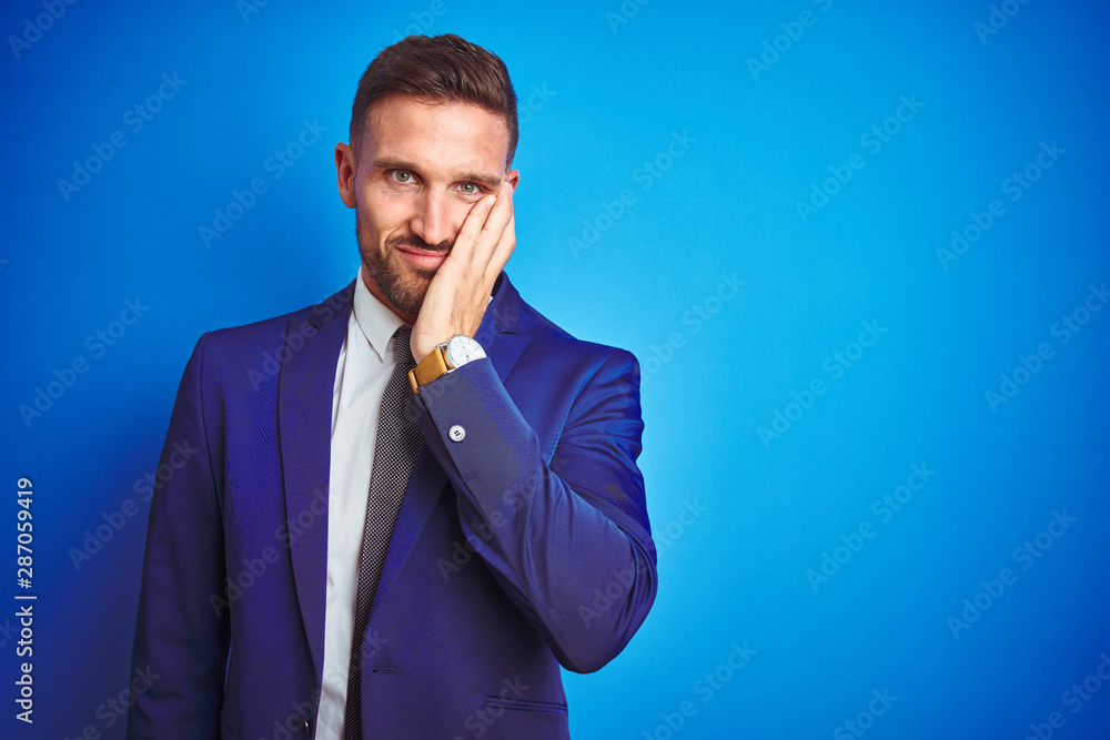 Young handsome business man over blue isolated background thinking looking tired and bored with depression problems with crossed arms. Young handsome business man over blue isolated background thinking looking tired and bored with depression problems with crossed arms.