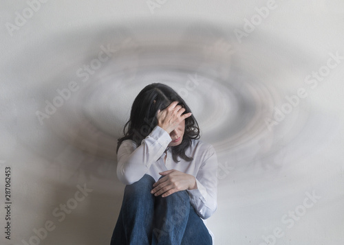 Vertigo illness with dizziness in woman patient feeling dizzy, faint with spinning movement inside head from benign paroxysmal positional vertigo (BPPV), migraine headaches, or hearing loss problem photo