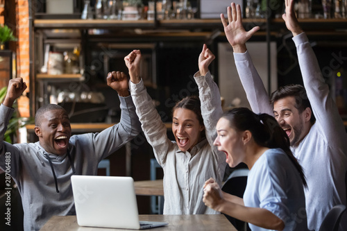 Canvas-taulu Euphoric diverse friends celebrating victory watching online game on laptop