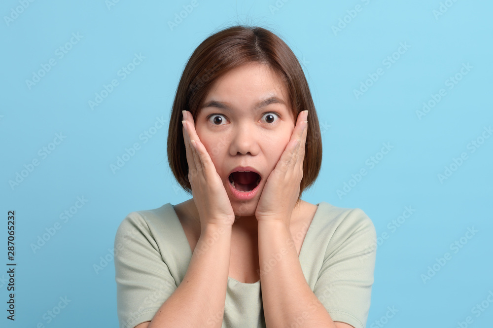 Shock / surprise and wow concept. Portrait of shocked asian woman open mouth being surprised or astonished to see large discounts sales campaign, isolated over blue background in studio. Shock / surprise and wow concept. Portrait of shocked asian woman open mouth being surprised or astonished to see large discounts sales campaign, isolated over blue background in studio.