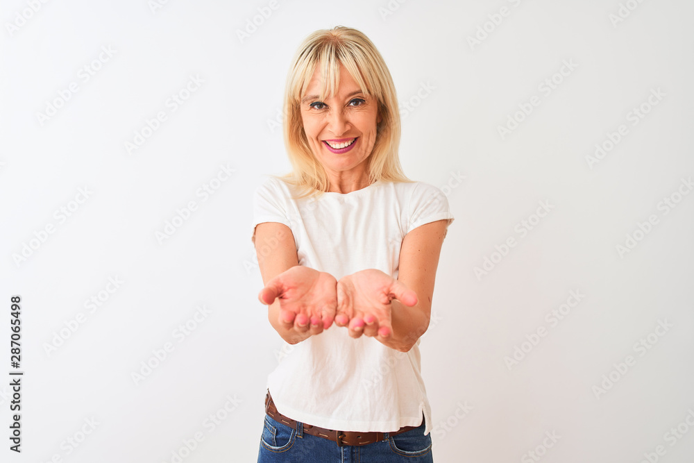 Middle age woman wearing casual t-shirt standing over isolated white background Smiling with hands palms together receiving or giving gesture. Hold and protection Middle age woman wearing casual t-shirt standing over isolated white background Smiling with hands palms together receiving or giving gesture. Hold and protection