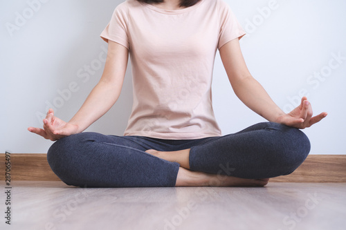 Yoga and meditation lifestyles. close up view of young beautiful woman practicing yoga namaste pose in the living room at home.