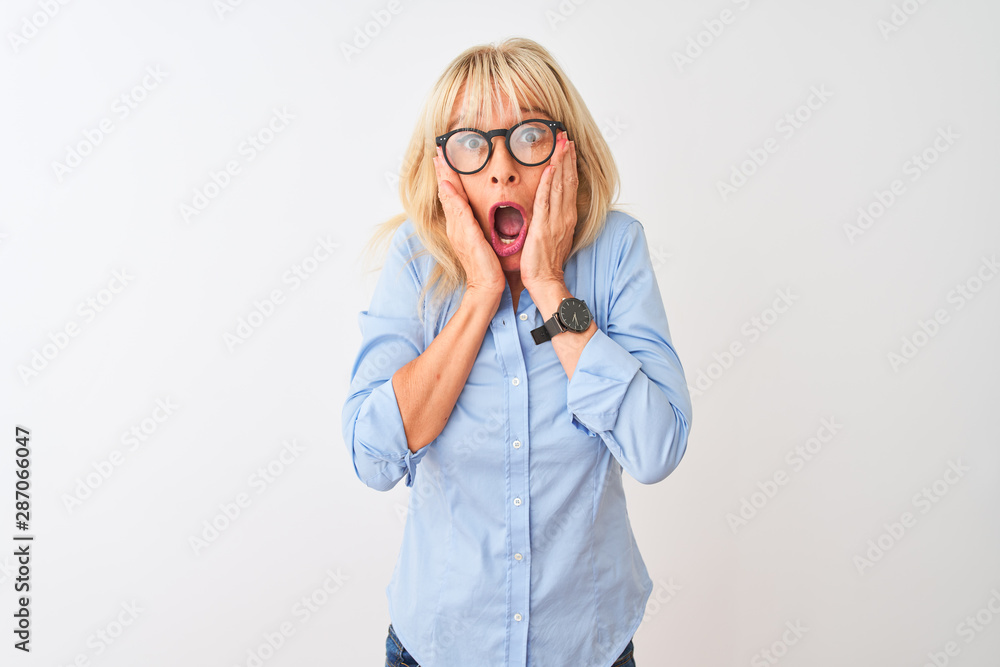 Middle age businesswoman wearing elegant shirt and glasses over isolated white background afraid and shocked, surprise and amazed expression with hands on face