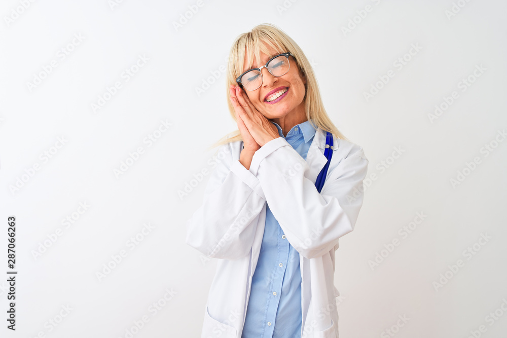 Middle age doctor woman wearing glasses and stethoscope over isolated white background sleeping tired dreaming and posing with hands together while smiling with closed eyes. Middle age doctor woman wearing glasses and stethoscope over isolated white background sleeping tired dreaming and posing with hands together while smiling with closed eyes.
