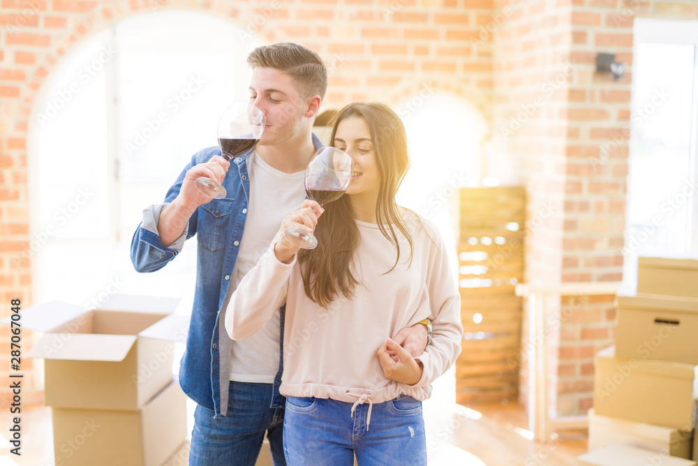 Young beautiful couple drinking a glass of wine celebrating moving to a new house Young beautiful couple drinking a glass of wine celebrating moving to a new house