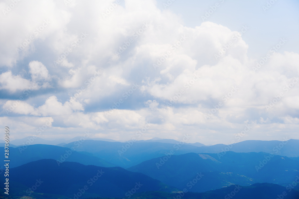 Beautiful mountains on the background of cloudy blue sky.