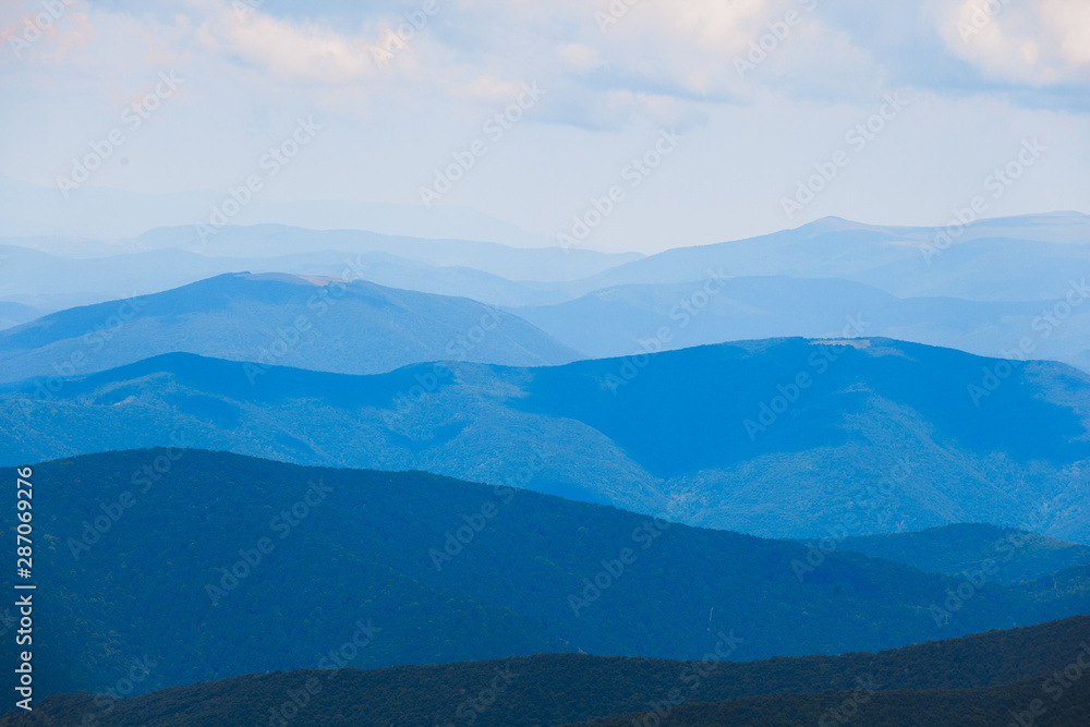 Mountain landscape of blue hills on the background of cloudy sky