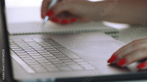 Wallpaper Mural Woman hands with red manicure using laptop to work study and writing on paper with a pen. Business, financial, trade stock maket and social network concept. Torontodigital.ca