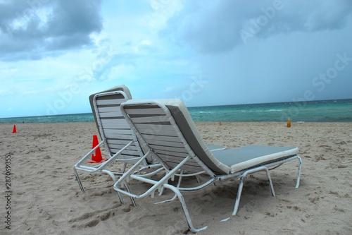Fototapeta Naklejka Na Ścianę i Meble -  Beach chairs at south beach miami as the first storm clouds of hurricane Dorian hangs in the sky