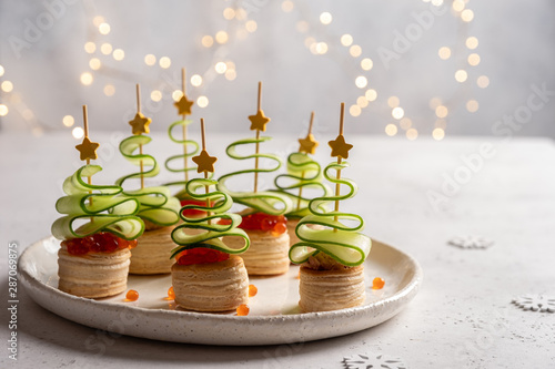 Foto Christmas tree canape with cucumber slice, salmon pate and red caviar for festiv