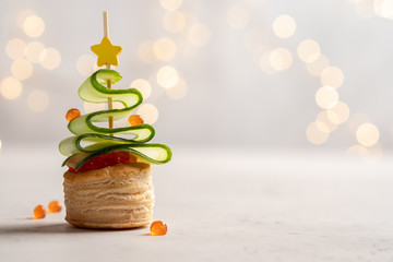 Christmas tree canape with cucumber slice, salmon pate and red caviar for festive xmas snack