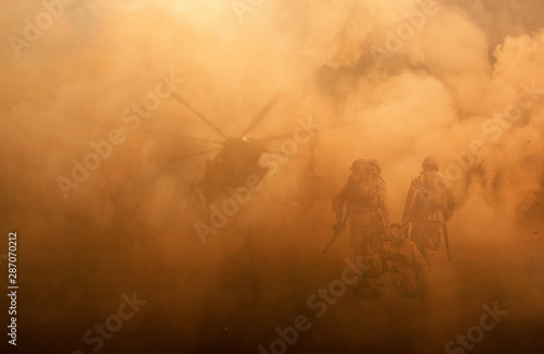 Fotografie, Tablou 2 soldiers helping wounded soldier between dust in battle field to board the hel
