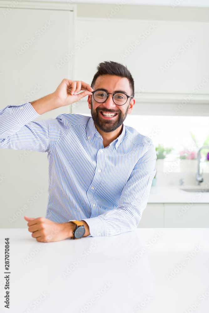 Handsome business man wearing glasses and smiling cheerful with confident smile on face